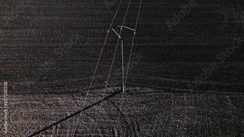 Aerial view of a power line in the middle of a rural road