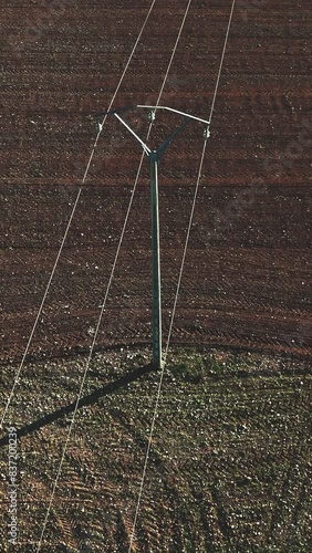vertical video in Aerial view of a power line in the middle of a rural road