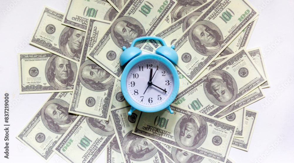 Time - money concept with clock and dollar bills closeup Time - money concept with clock and dollar bills closeup