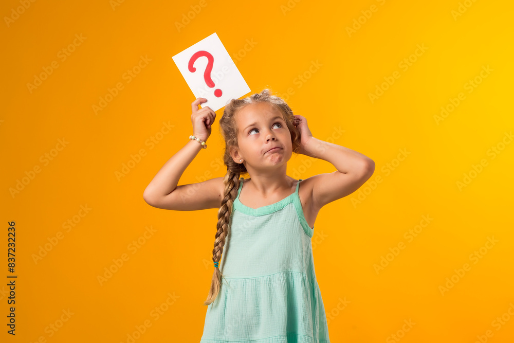 Thoughtful kid girl holding question mark card and scratching her head. Children, idea and knowledge concept Thoughtful kid girl holding question mark card and scratching her head. Children, idea and knowledge concept
