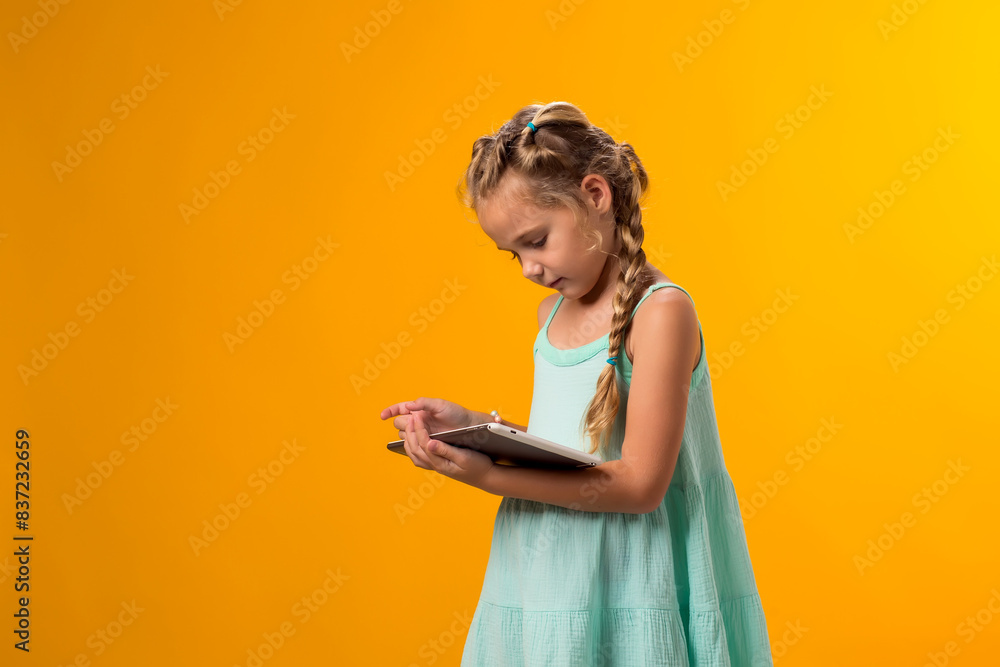 Smiling girl holding smartprone in hand on yellow background. Lifestyle, leasure and gadget addiction concept Smiling girl holding smartprone in hand on yellow background. Lifestyle, leasure and gadget addiction concept