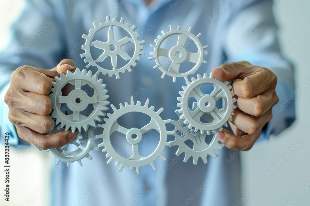 An illustration of a businessman holding some iron gears, which are the symbol of managing and planning the way to run his business efficiently.