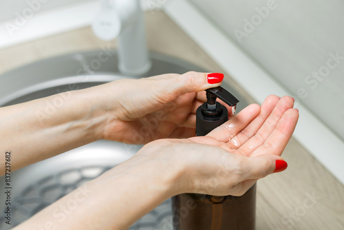 housewife using liquid soap dispenser in the kitchen  close-up.  bottle of liquid soap. using a soap dispenser. 