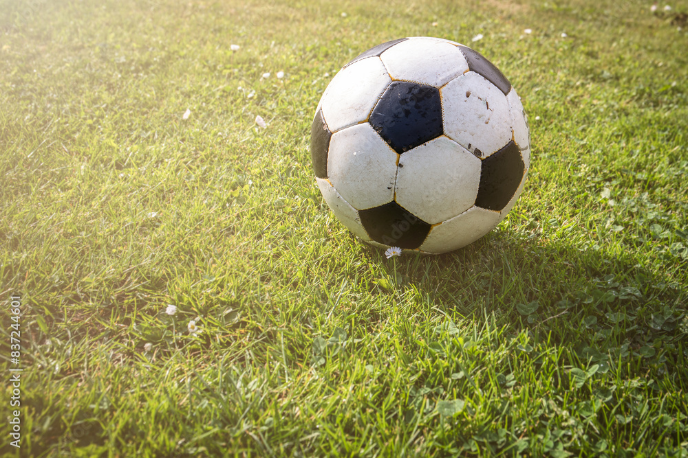 Obraz premium Ball of football game in grass , sun glare from corner