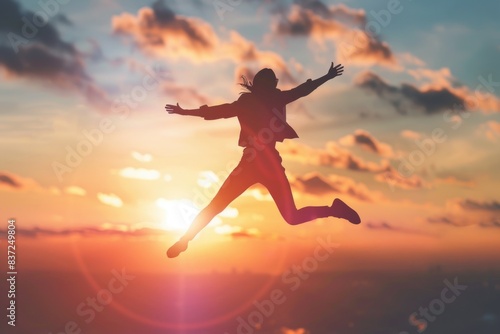 A person leaping into the air at sunset  with a beautiful orange and pink sky in the background
