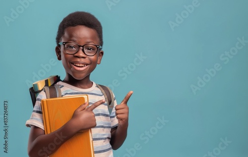 Smiling Young Girl Wearing Glasses Holds Textbook Against Blue Background