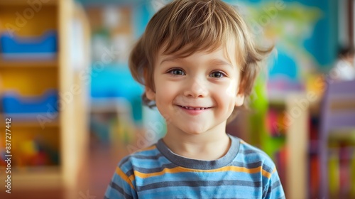 Boy in kindergarten, smiling boy, toys and colorful walls blurred in the background