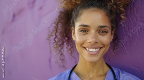 Smiling Female Nurse Standing Near Purple Wall