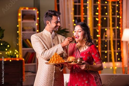 Happy young indian couple celebrate diwali festival, husband put