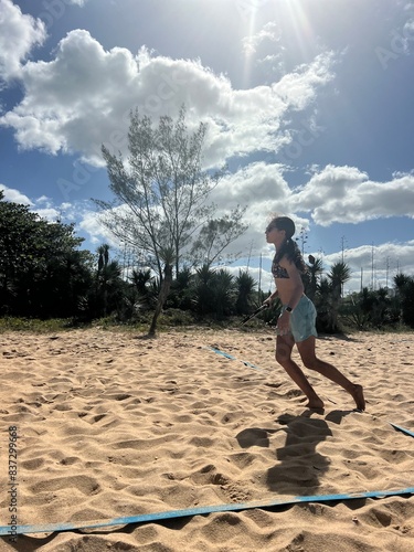 girl playing beach tennis on the beach