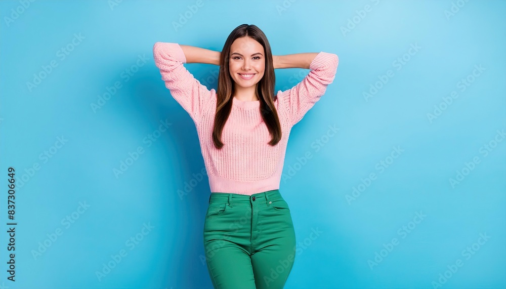 adorable gorgeous girl wear pink knit top green trousers hold arms behind head isolated on blue color background adorable gorgeous girl wear pink knit top green trousers hold arms behind head isolated on blue color background