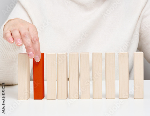 Wooden blocks on the table, a woman's hand holds one. The concept of finding unique