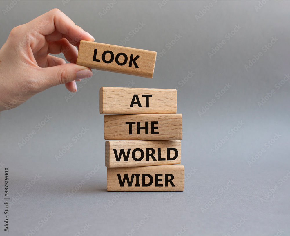 Look at the world wider symbol. Wooden blocks with words Look at the world wider. Beautiful grey background. Businessman hand. Business and Look at the world wider concept. Copy space. Look at the world wider symbol. Wooden blocks with words Look at the world wider. Beautiful grey background. Businessman hand. Business and Look at the world wider concept. Copy space.