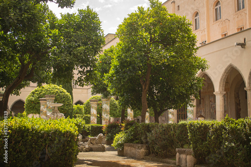Foto Pathway through a park with fountain and beautiful tiled pillars plated at the cloister garden of Santa Chiara Monastery, Naples, Italy