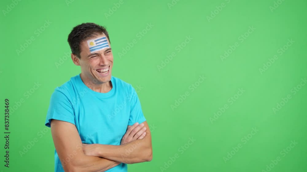 Happy man with uruguayan flag painted on face looking away Happy man with uruguayan flag painted on face looking away
