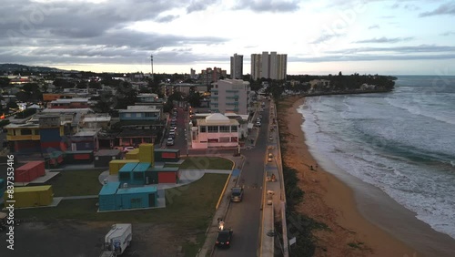 aerial view of luquillo puerto rico skyline with waves crashing on the beach (tropical caribbean island town at sunset, dusk) night time tall hotel apartment buildings sand sea ocean paradise photo