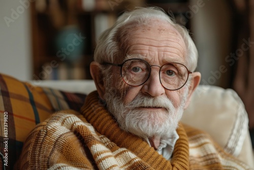 Senior male in glasses & scarf on sofa photo