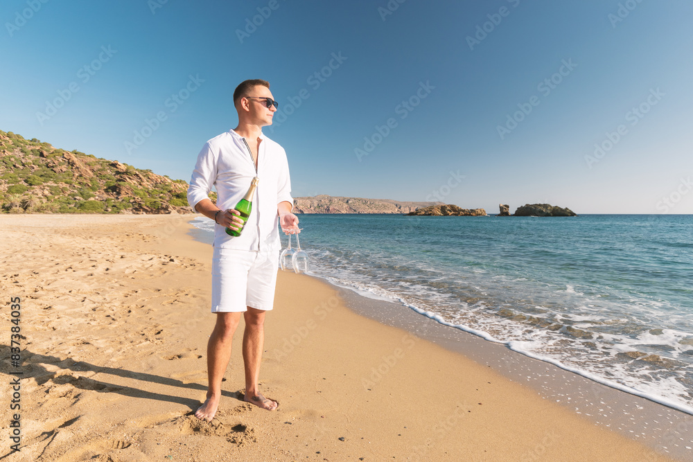 Handsome happy man with champagne on the beach. Summer vacations concept. Handsome happy man with champagne on the beach. Summer vacations concept.