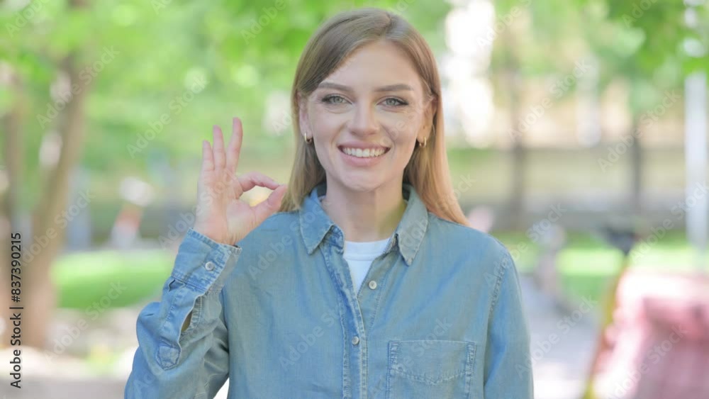 Young Woman with Okay Sign Outdoor in Park Young Woman with Okay Sign Outdoor in Park
