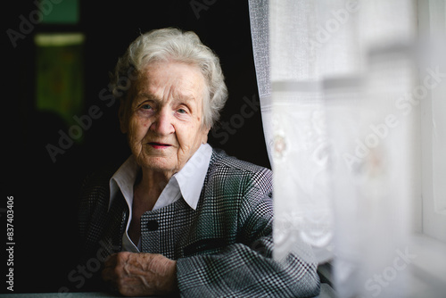 An elderly lady poses for a portrait, looking directly at the camera with grace and dignity.