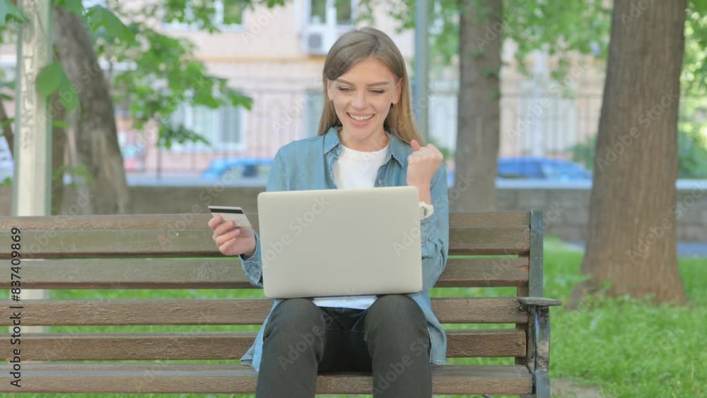 Woman Enjoying Online Shopping while Sitting on Bench in Park Woman Enjoying Online Shopping while Sitting on Bench in Park