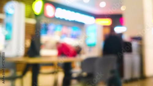 Unfocused 4k footage with terminals for online ordering food at a fast food restaurant on the food court of a shopping mall. Images of dishes change on the terminal screens. It can be used as a