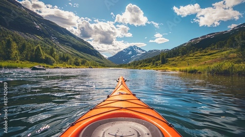 First-person view of an orange kayak on a river in mountains on a sunny day, nature