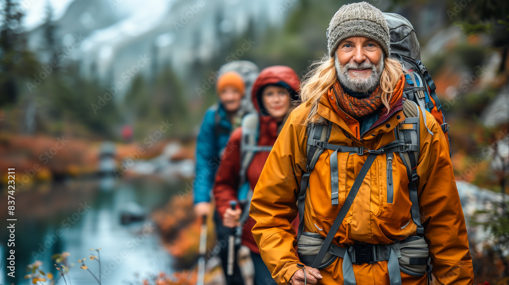 Group of senior hikers trekking through a scenic mountain trail during autumn Group of senior hikers trekking through a scenic mountain trail during autumn