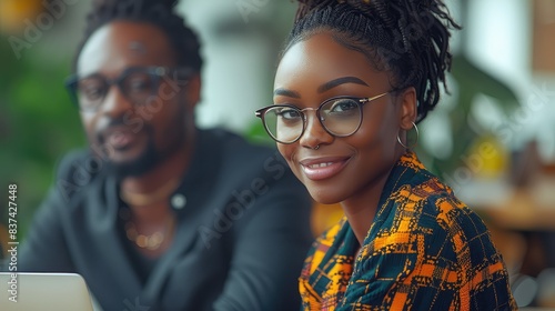 Focused Collaboration: A Black Woman and Man Engaged in Productive Teamwork at an Office Desk