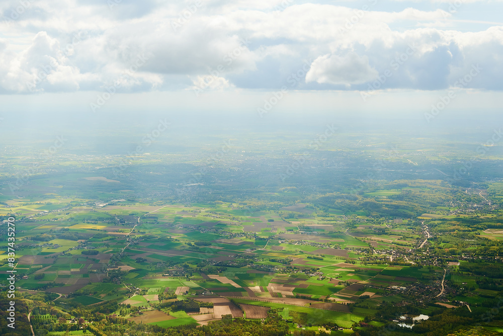 An aerial view of European countryside and green agricultural fields from an airplane window.