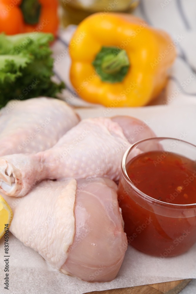 Fresh marinade and raw chicken drumsticks on board, closeup Fresh marinade and raw chicken drumsticks on board, closeup