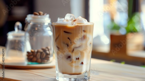 Creamy Iced Coffee with Whipped Topping. A refreshing glass of iced coffee, topped with whipped cream, shown in a cafe setting with scattered coffee beans.
