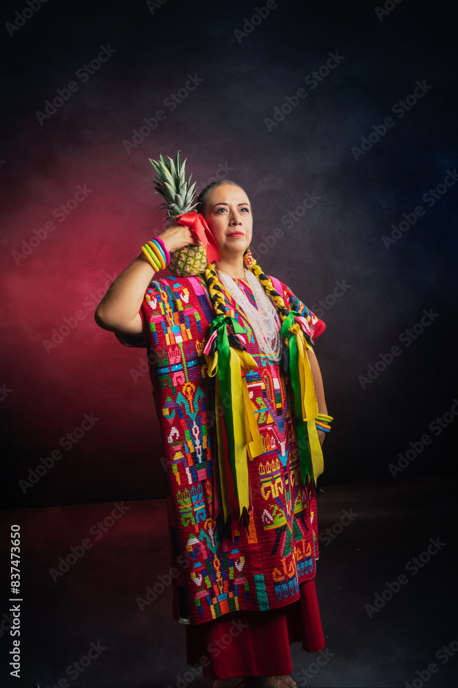 Fototapeta premium A woman wearing a colorful dress holding a pineapple