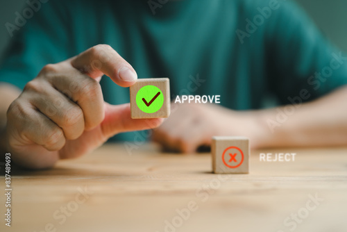 Businessman's hand chooses the one wooden cube block with the green right for approve and reject business proposal, Moral choosing option concept.