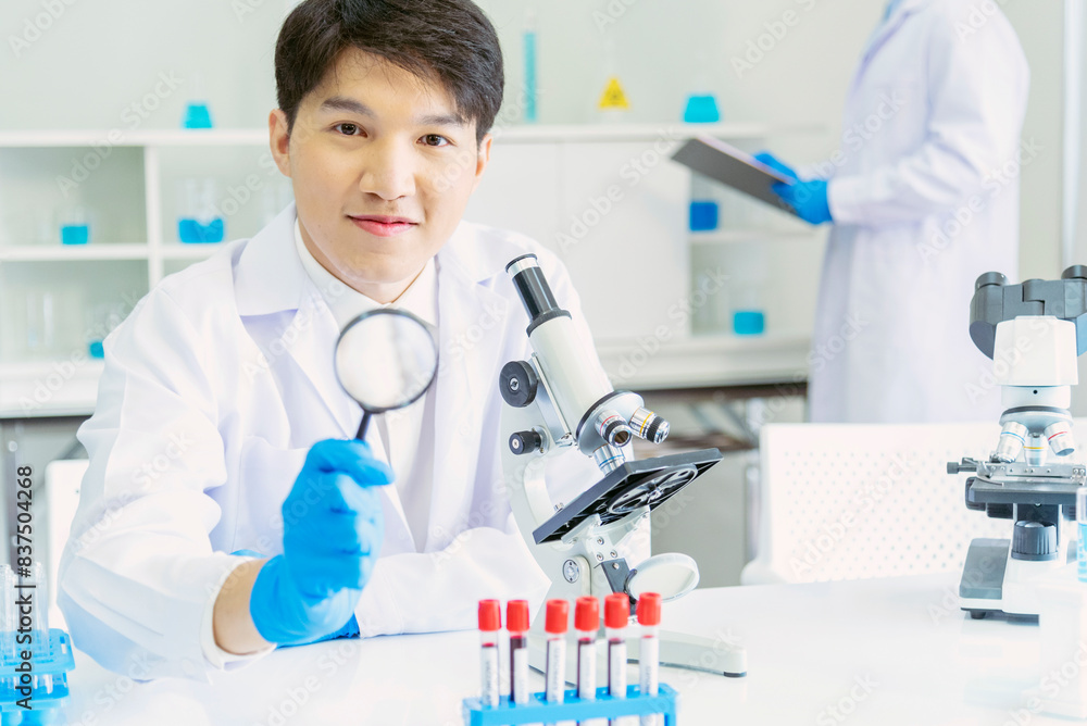 Scientist man look into Microscope research in science laboratory. Asian scientist look at microbiology microscope laboratory equipment chemistry lab. Biochemistry research experiment vaccine concept Scientist man look into Microscope research in science laboratory. Asian scientist look at microbiology microscope laboratory equipment chemistry lab. Biochemistry research experiment vaccine concept