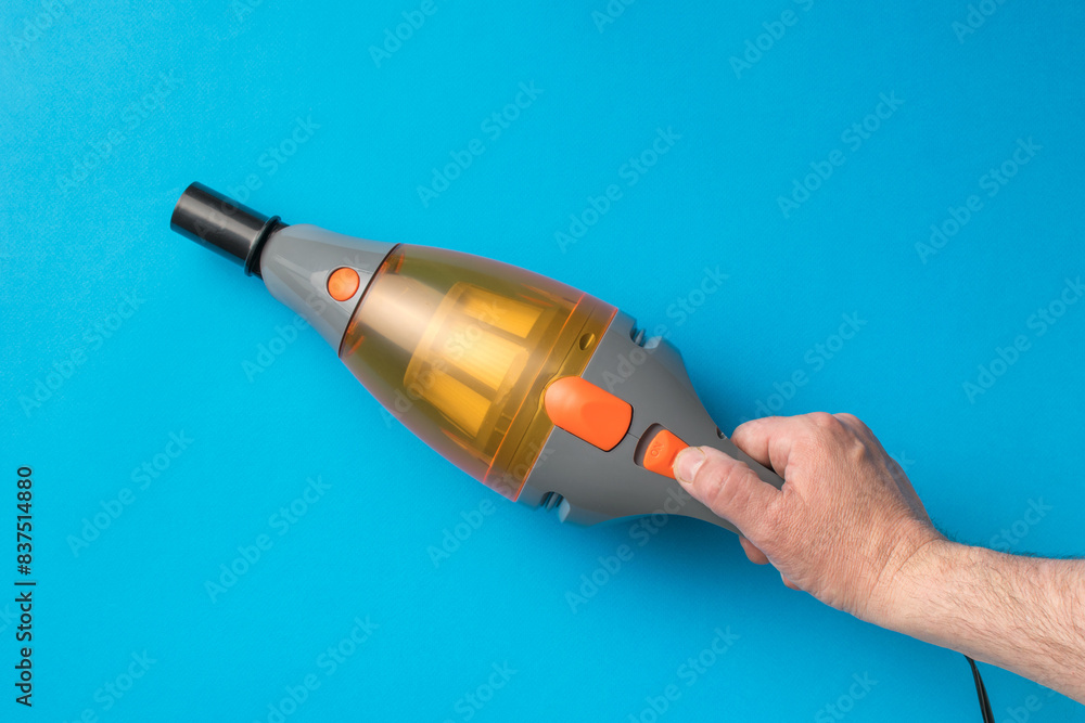 Portable Handheld Vacuum Cleaner in Use on Blue Background Portable Handheld Vacuum Cleaner in Use on Blue Background