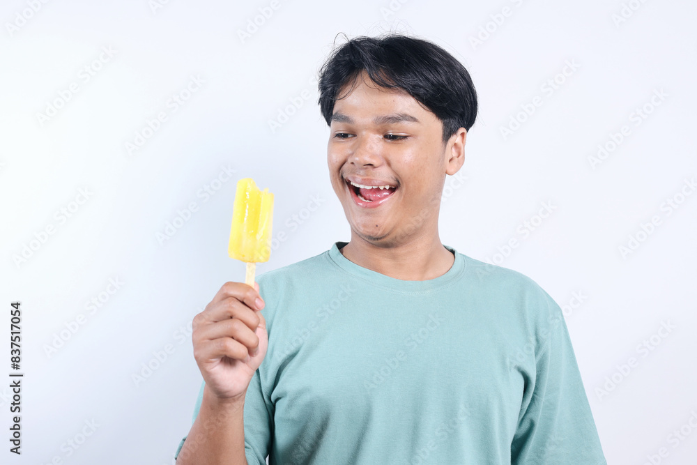 Cheerful Young Asian Man Holding Ice Cream Isolated On White Background Cheerful Young Asian Man Holding Ice Cream Isolated On White Background