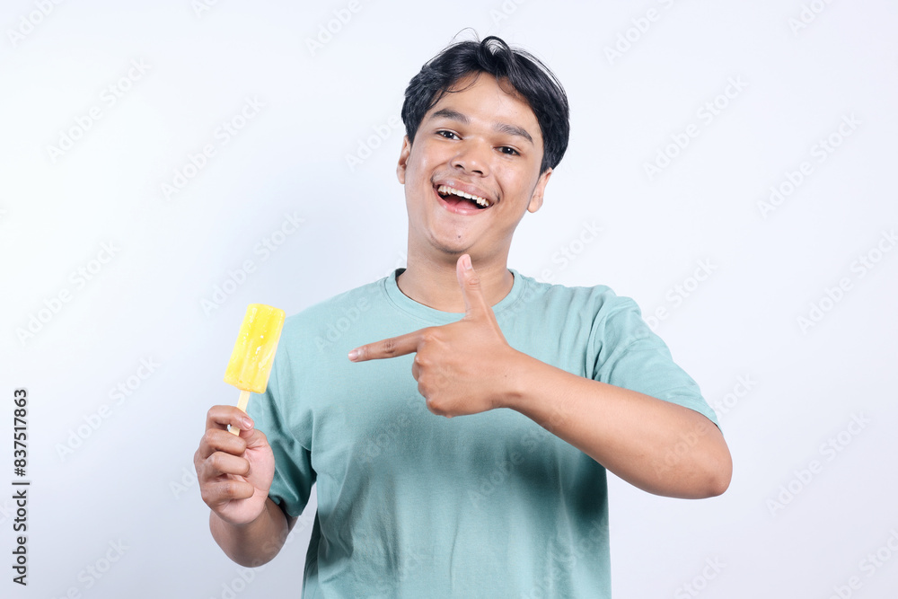 Cheerful Young Asian Man Holding And Pointing Ice Cream Stick Isolated White Background Cheerful Young Asian Man Holding And Pointing Ice Cream Stick Isolated White Background