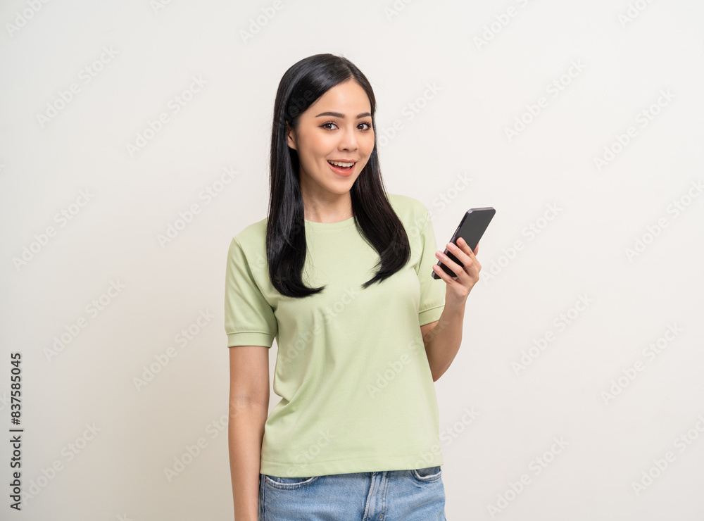 Pretty young asian woman using cellphone standing on isolated white background. Happy Excited Beautiful young asian shopping online payment with mobile phone. Playing game on smartphone Pretty young asian woman using cellphone standing on isolated white background. Happy Excited Beautiful young asian shopping online payment with mobile phone. Playing game on smartphone