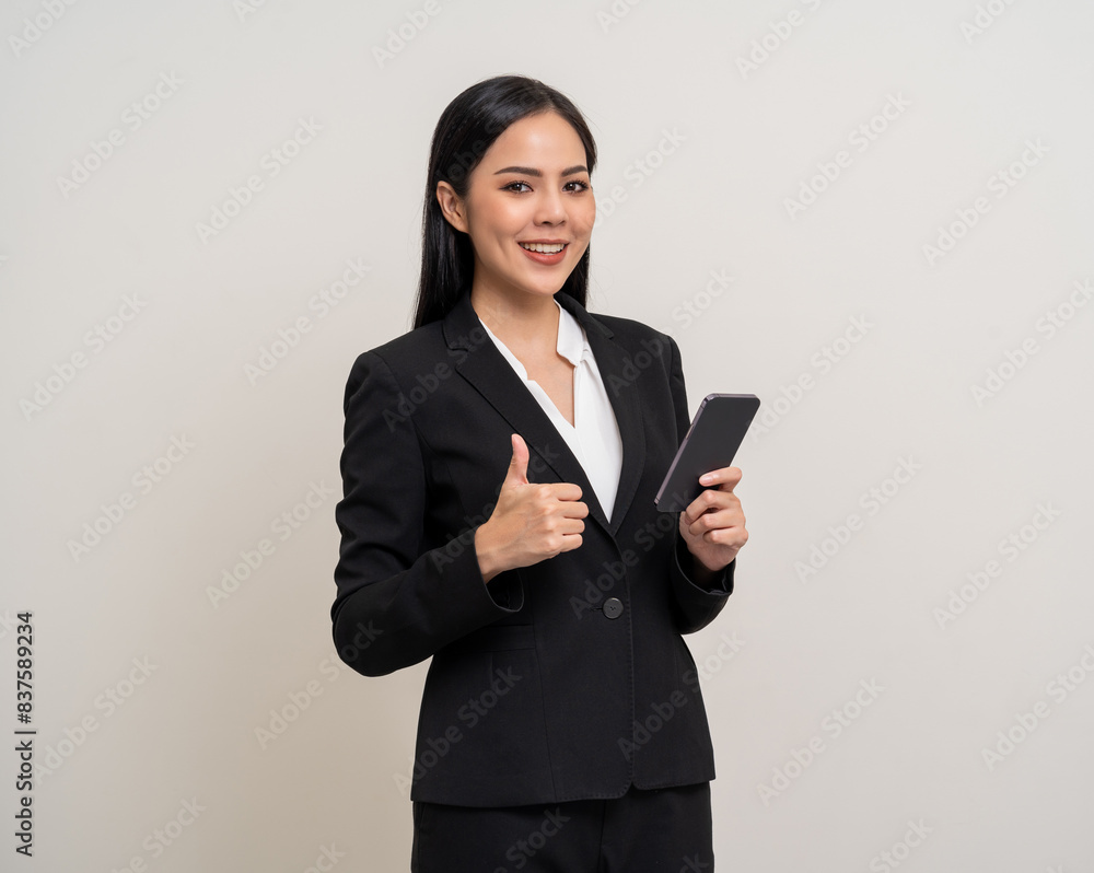 Attractive elegant young asian business woman using cellphone standing on isolated background. Happy Excited young asian female formal black suit holding smartphone contract service with customer Attractive elegant young asian business woman using cellphone standing on isolated background. Happy Excited young asian female formal black suit holding smartphone contract service with customer