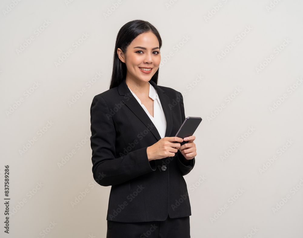 Attractive elegant young asian business woman using cellphone standing on isolated background. Happy Excited young asian female formal black suit holding smartphone contract service with customer Attractive elegant young asian business woman using cellphone standing on isolated background. Happy Excited young asian female formal black suit holding smartphone contract service with customer