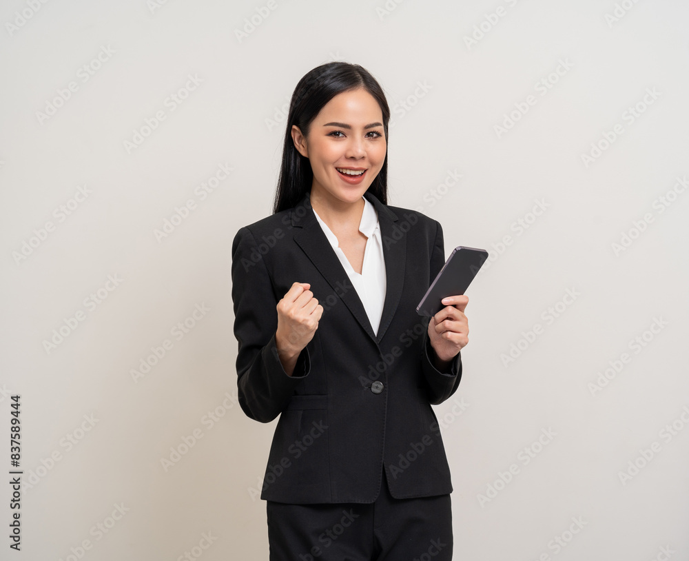 Attractive elegant young asian business woman using cellphone standing on isolated background. Happy Excited young asian female formal black suit holding smartphone contract service with customer Attractive elegant young asian business woman using cellphone standing on isolated background. Happy Excited young asian female formal black suit holding smartphone contract service with customer