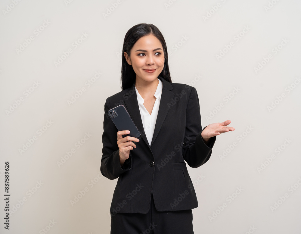 Attractive elegant young asian business woman using cellphone standing on isolated background. Happy Excited young asian female formal black suit holding smartphone contract service with customer Attractive elegant young asian business woman using cellphone standing on isolated background. Happy Excited young asian female formal black suit holding smartphone contract service with customer