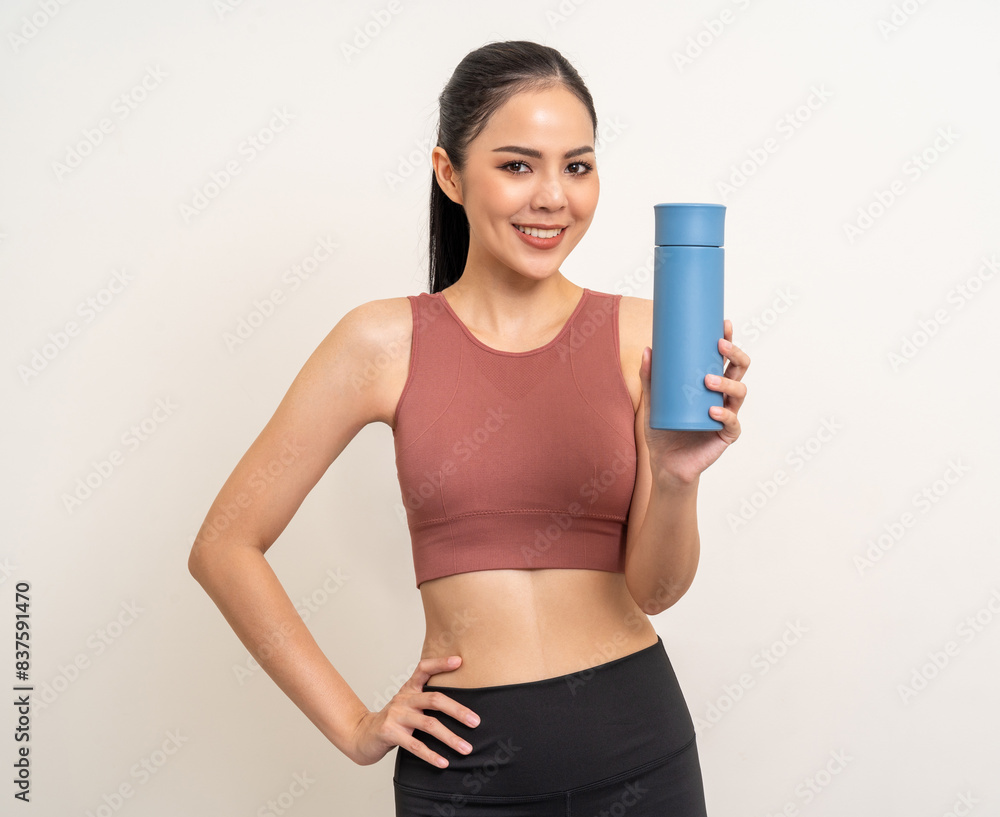 Young beautiful asian woman in sportswear holding bottle of water on isolated background. Portrait happy healthy slim fit and firm latin attractive sporty woman drinking water after exercise workout Young beautiful asian woman in sportswear holding bottle of water on isolated background. Portrait happy healthy slim fit and firm latin attractive sporty woman drinking water after exercise workout