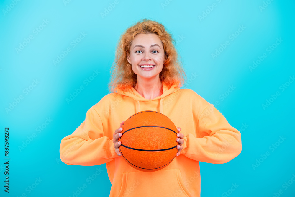 Fototapeta premium Professional basketball player training. Woman has sport motivation. Sport and hobby. Sport game. Sportswoman with ball. Woman with basketball ball isolated on blue. Young basketball player with ball