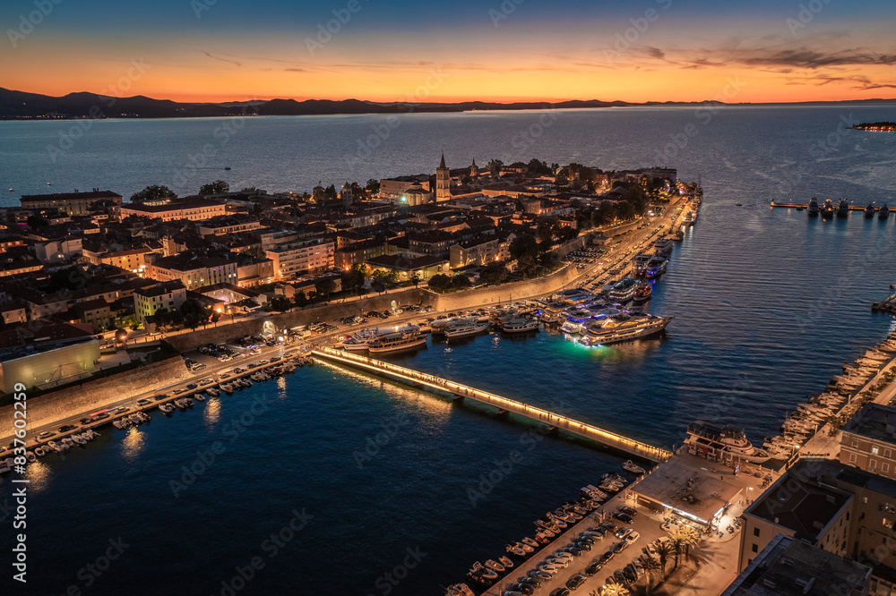 Zadar, Croatia - Aerial view of the illuminated City Bridge (Gradski most) with the old town of Zadar, Cathedral of St. Anastasia tower, yacht marina and golden sunset sky Zadar, Croatia - Aerial view of the illuminated City Bridge (Gradski most) with the old town of Zadar, Cathedral of St. Anastasia tower, yacht marina and golden sunset sky