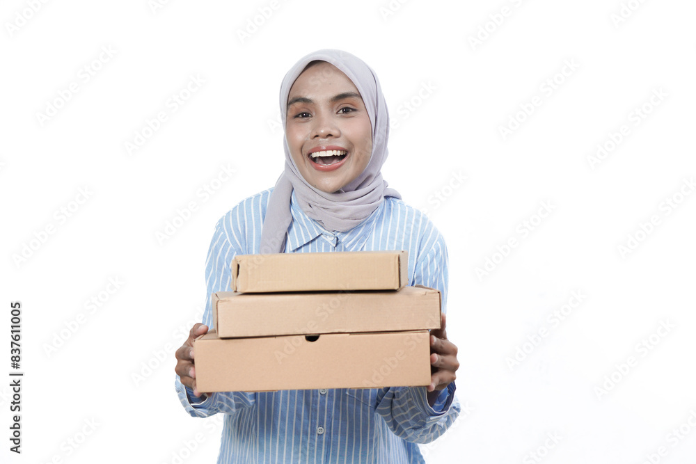 Smiling friendly Asian Muslim Woman in blue white shirt holding package box isolated on white background. Smiling friendly Asian Muslim Woman in blue white shirt holding package box isolated on white background.