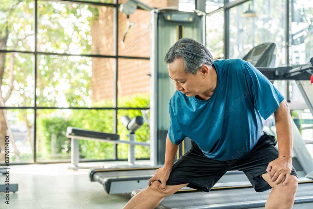 Senior asian man wearing sportswear warming up in fitness gym before exercise. Mature man stretching arm before running. Training athlete work out Senior asian man wearing sportswear warming up in fitness gym before exercise. Mature man stretching arm before running. Training athlete work out