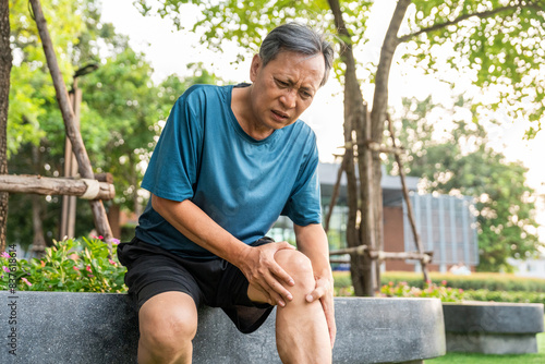 Fotografi Mature man tired and leg pain during jogging at nature park