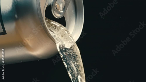 White wine, rose or off white liquid pouring out of silver can in super slow motion, black background of canned drink at 4k 800fps photo